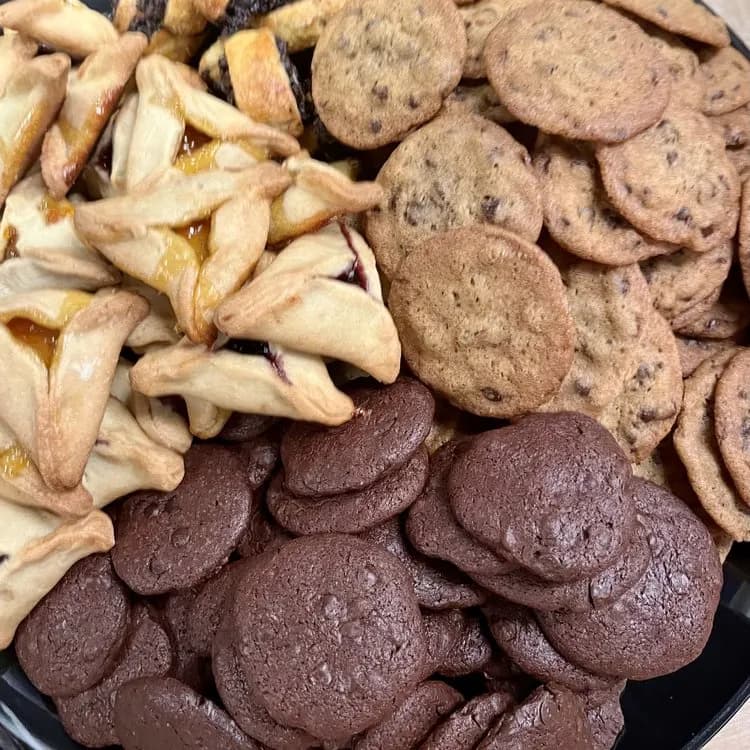 A dessert tray of chocolate chip cookies, chocolate cookies and hamantaschen